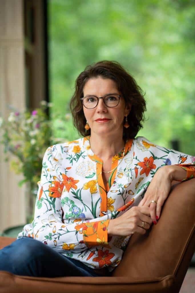 Marlies van Beek, life coach, rustig zittend in haar praktijk in Doorn met uitzicht op het bos